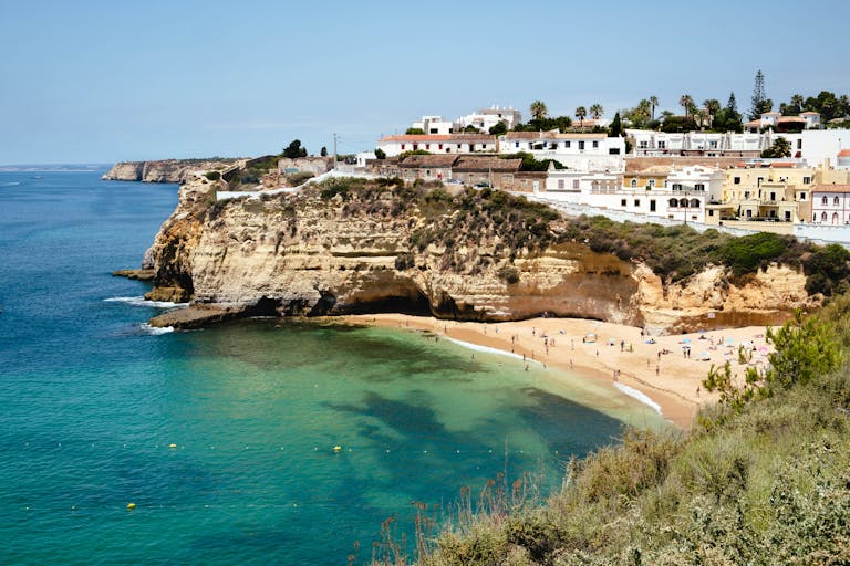 Beautiful coastal view of cliffs and beach in Faro District, Portugal, during summer.